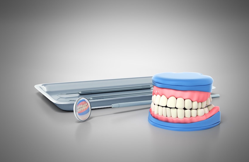 illustration of dental tools laying next to a set of fake teeth