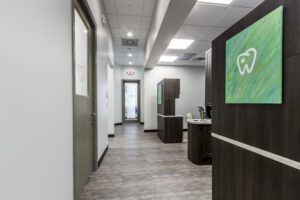 Texsmiles' dental office interior with a vibrant green wall and classic wooden doors, providing a serene and inviting space for visitors.