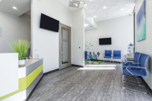 A modern office space showcasing a dental reception desk accompanied by comfortable seating arrangements for guests.
