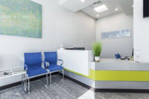 Texsmiles dental office reception area featuring blue chairs arranged for patient seating and a welcoming atmosphere.