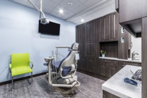 A dental office featuring a comfortable chair and a sink, designed for patient care and dental procedures.